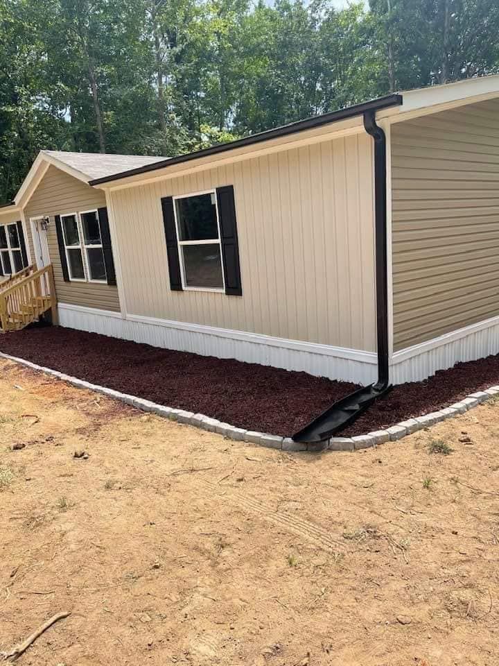 A mobile home is sitting on top of a dirt field.