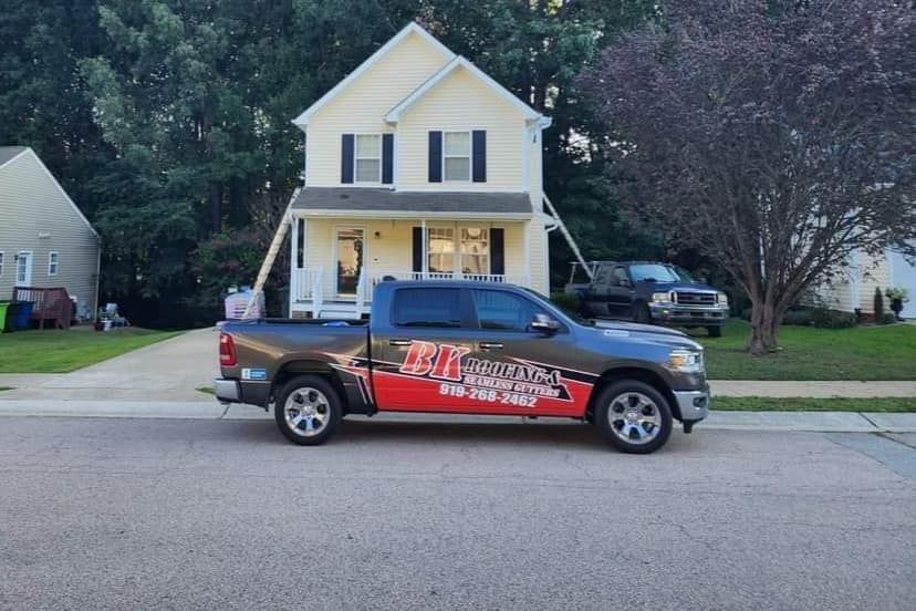 A ram truck is parked in front of a house.