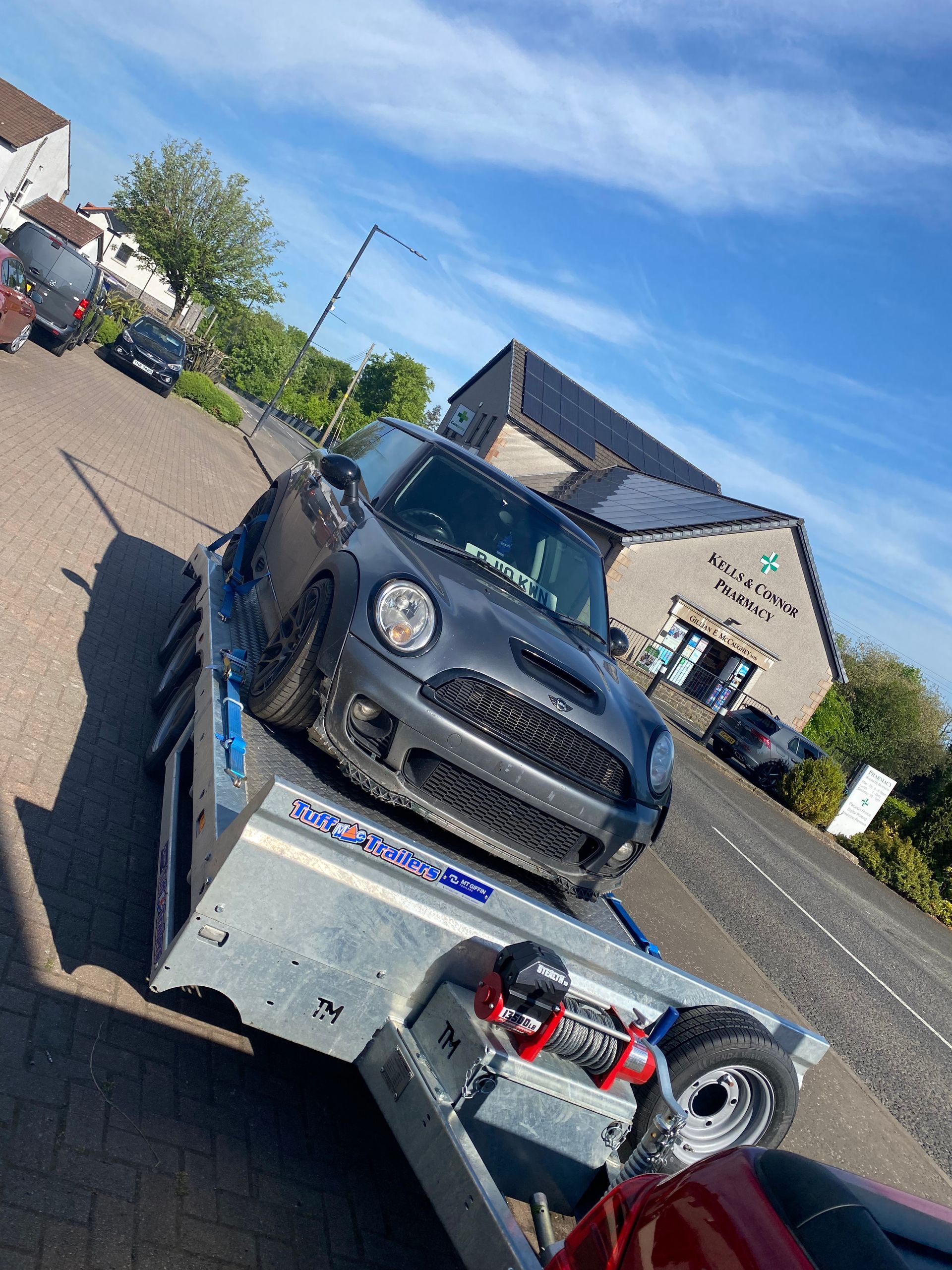 An unwanted car is being towed on a trailer  on its way to be professionally disposed of.