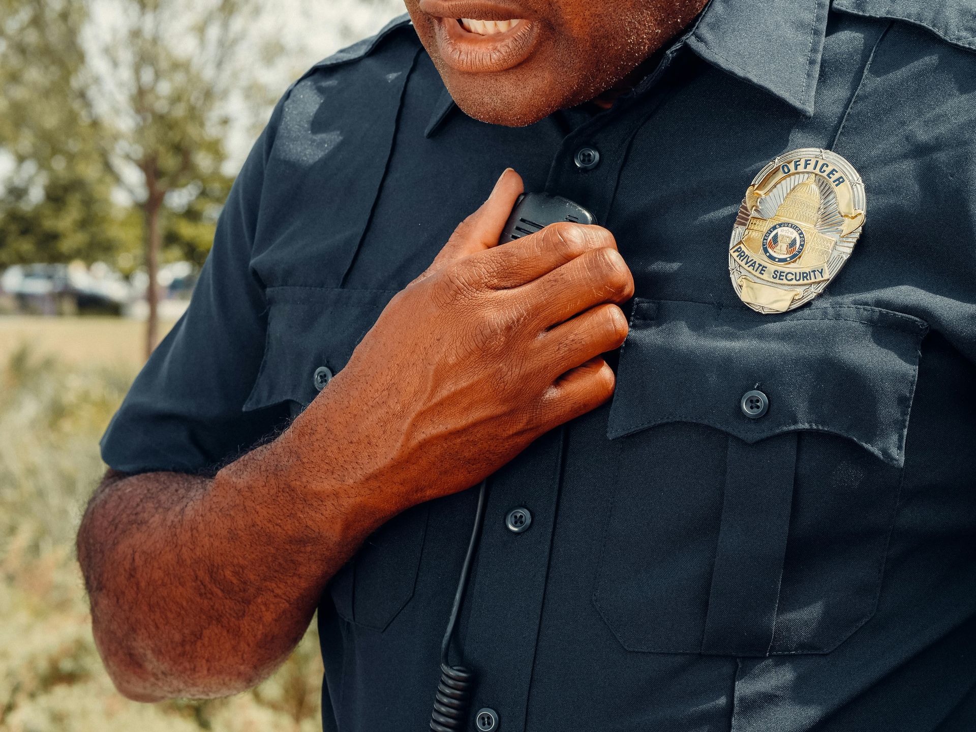 A security  officer is talking on a walkie talkie.