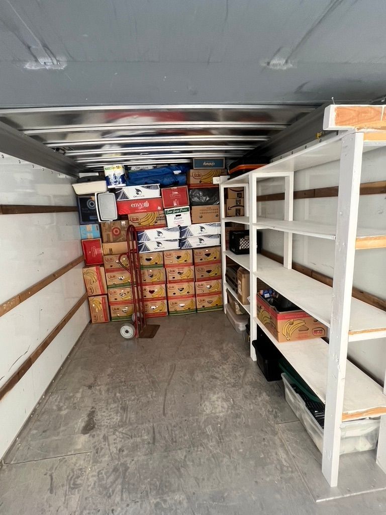 The inside of a truck filled with boxes and shelves.