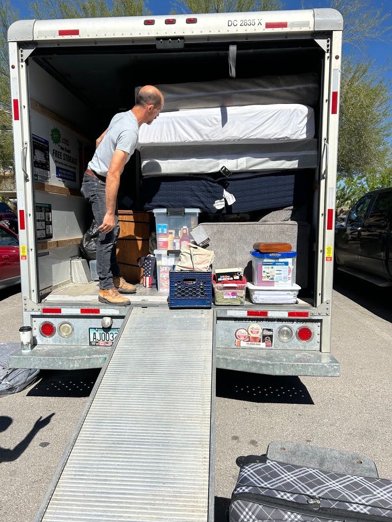 A man is loading a mattress into a moving truck.