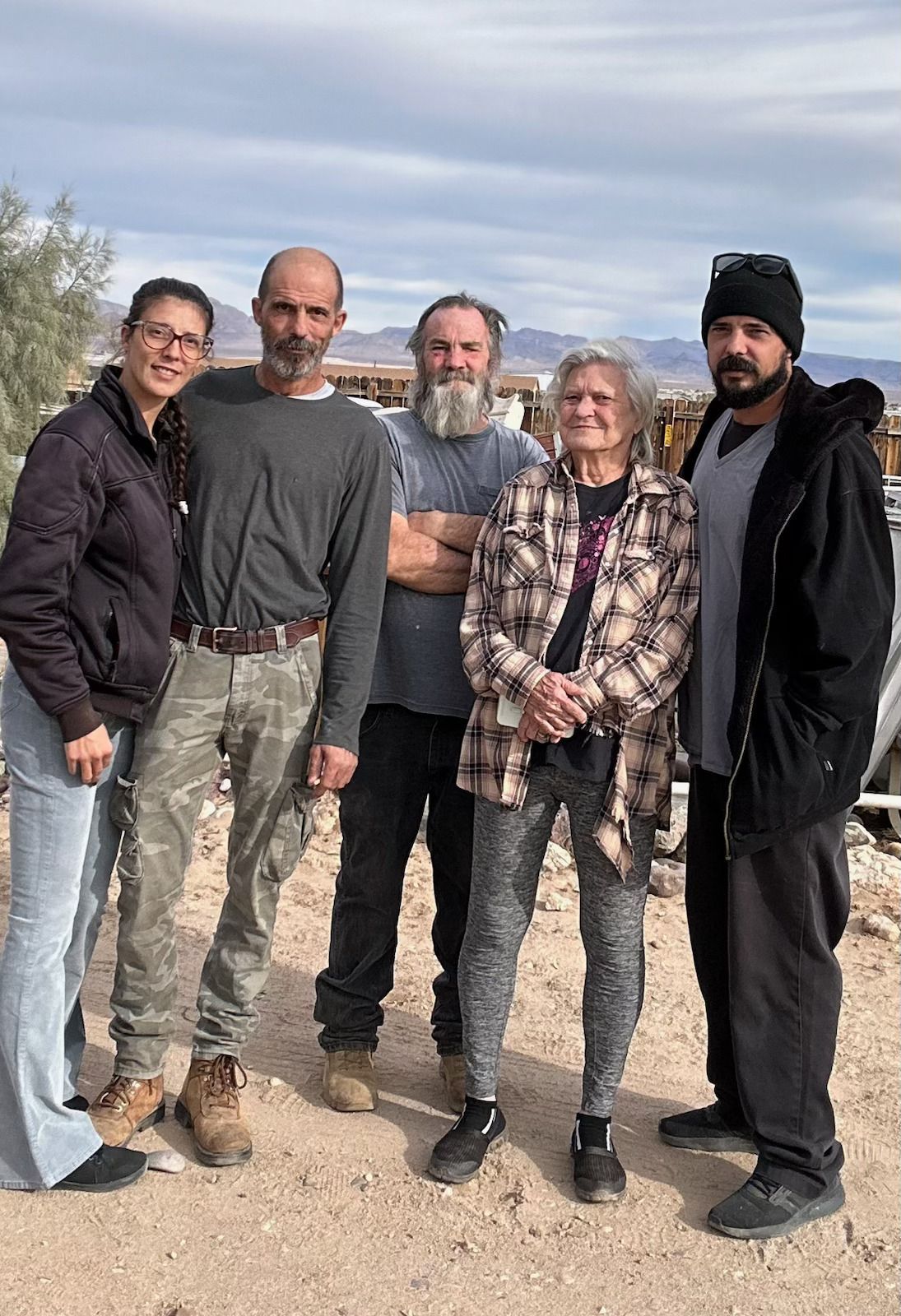 A group of people are posing for a picture in the desert.