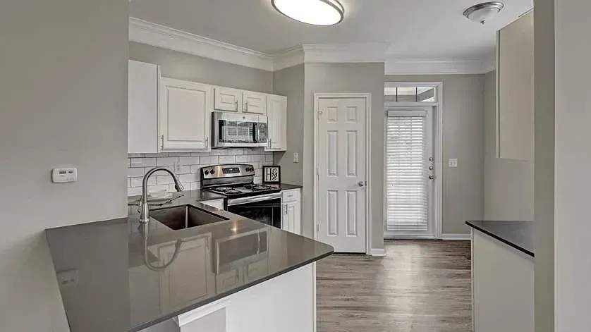 Modern kitchen with granite countertops, stainless steel appliances, and a breakfast bar at Woodland Pointe in Nashville, TN.
