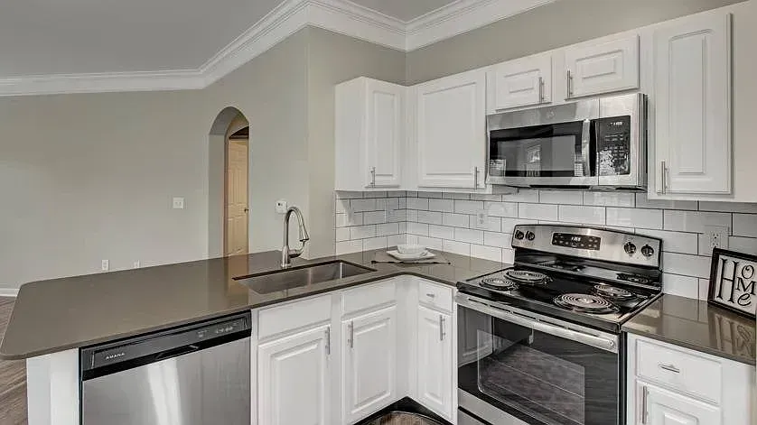 Modern kitchen with stainless steel appliances and white cabinets at Woodland Pointe in Nashville, TN.