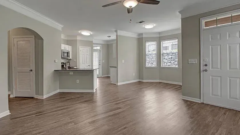 Spacious living room and kitchen area with wood-look flooring and a ceiling fan at Woodland Pointe in Nashville, TN.
