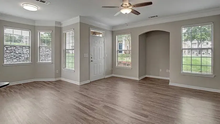 Living room with ceiling fan, natural light, and wood-look flooring at Woodland Pointe in Nashville, TN.