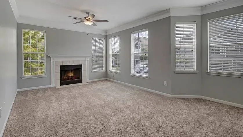 Spacious living room with a fireplace and large windows at Woodland Pointe in Nashville, TN.