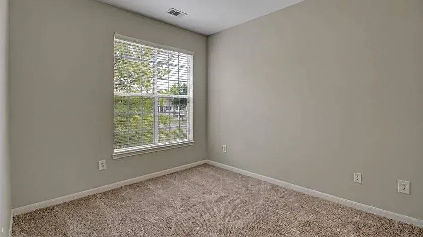 Empty bedroom with a large window and carpeted floor at Woodland Pointe in Nashville, TN.