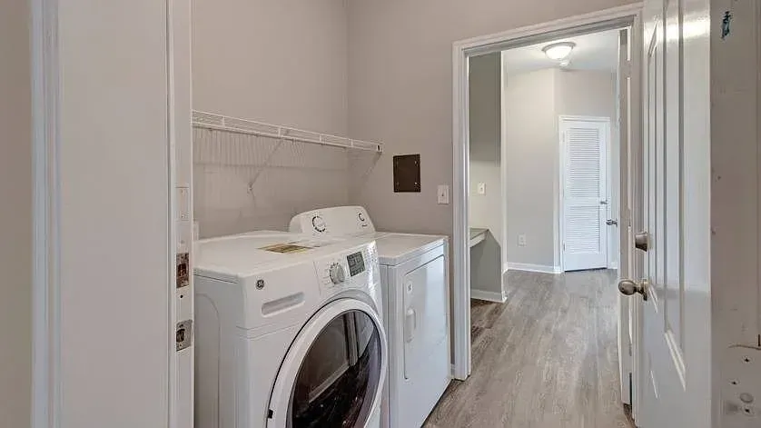 Washer and dryer in a laundry room with a shelf above at Woodland Pointe in Nashville, TN.