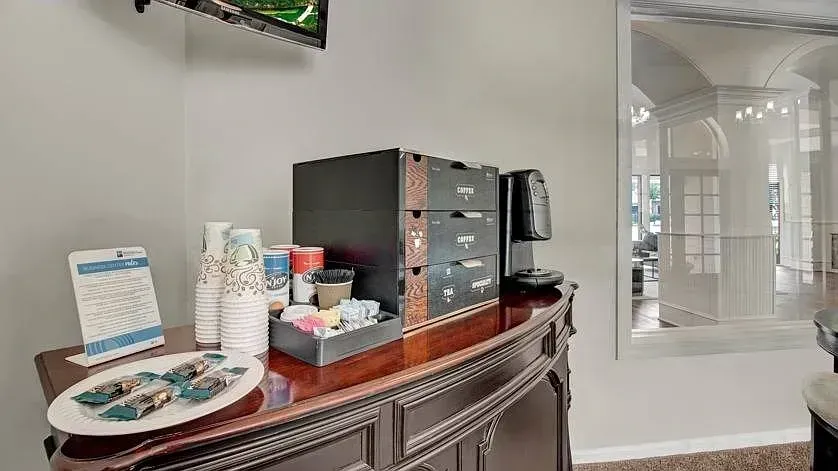 Coffee and tea station with coffee maker, cups, and snacks at Woodland Pointe in Nashville, TN.
