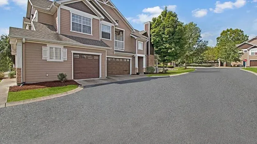 Exterior view of apartment buildings with garages and a paved road at Woodland Pointe in Nashville, TN.