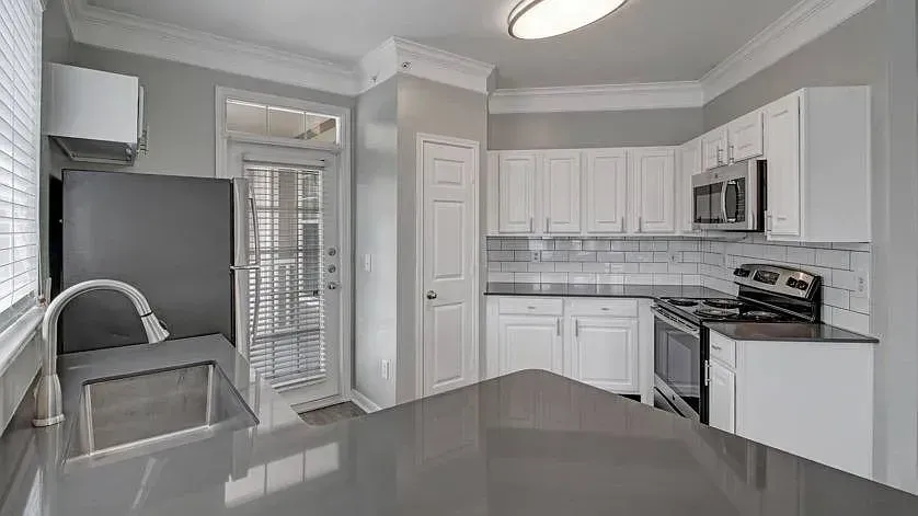 Modern kitchen with white cabinets, stainless steel appliances, and a large island at Woodland Pointe in Nashville, TN.