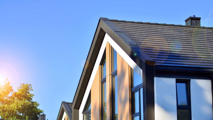 The sun is shining on the roof of a house