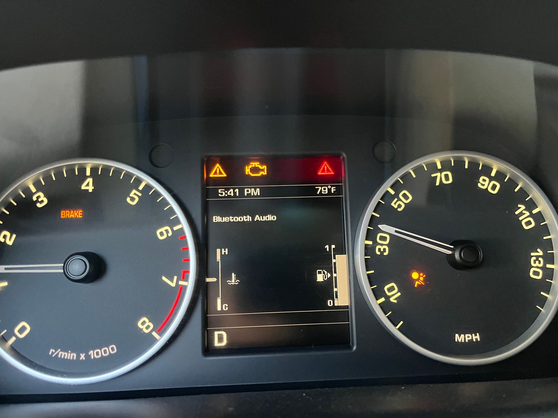 Car dashboard showing active warning lights including a check engine light, airbag warning, and fuel indicator.