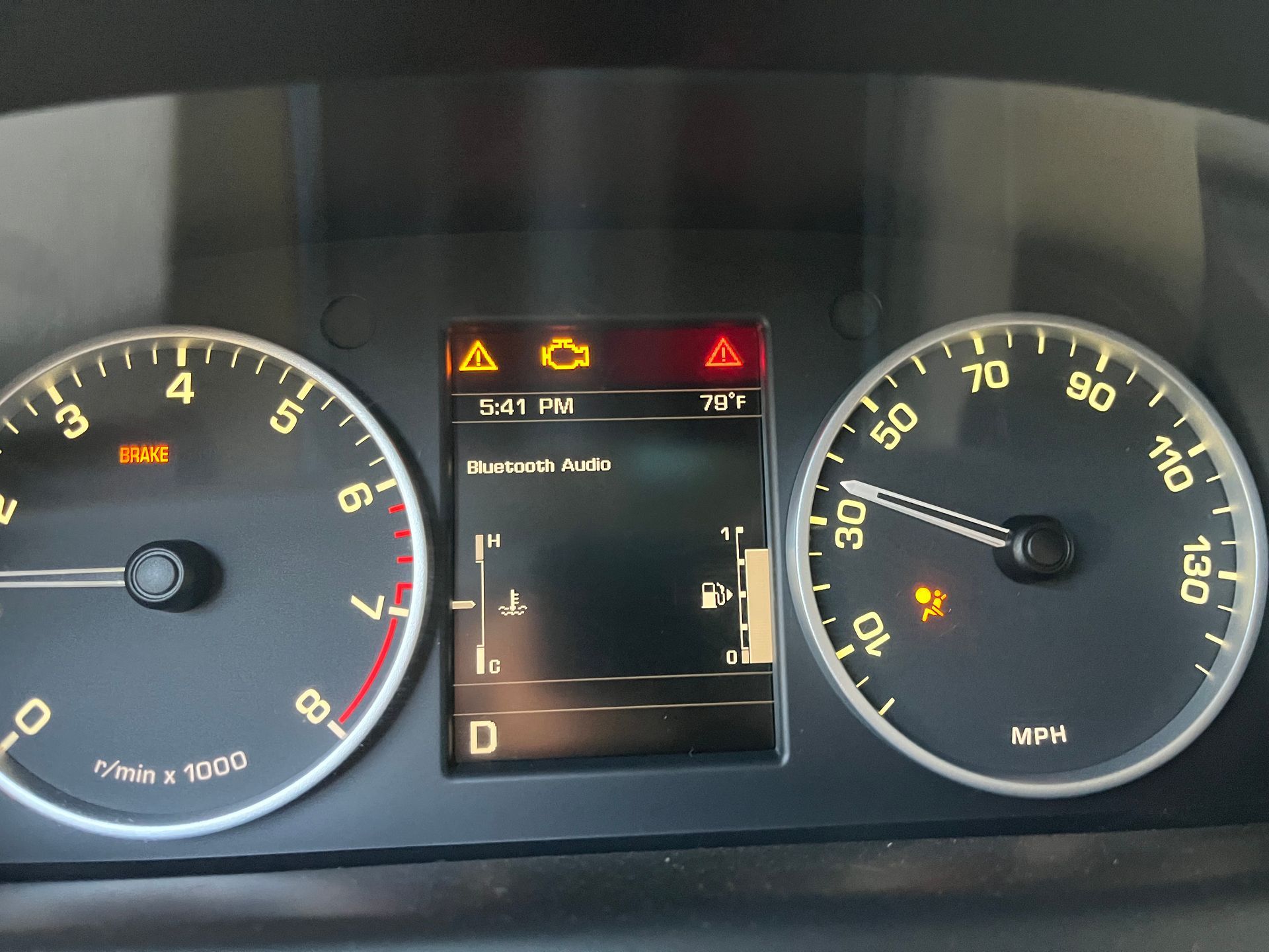 Car dashboard with speedometer at 35 mph, lit check engine, airbag, and other warning icons on the digital display.