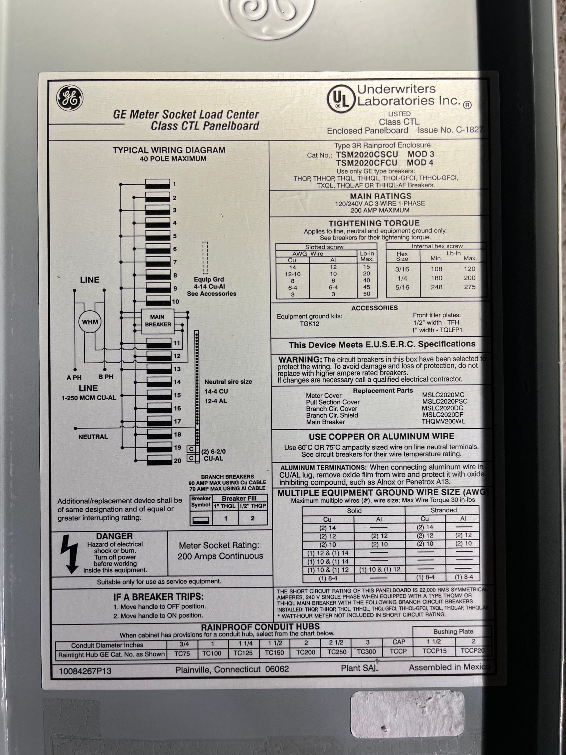 A GE load center wiring diagram label on a gray metal panel, featuring technical specifications and electrical symbols.