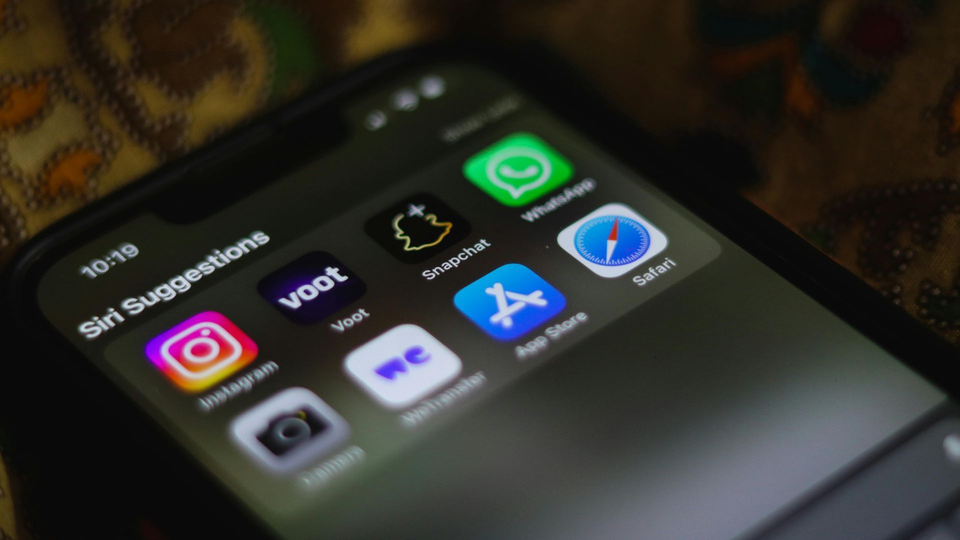 Een smartphone van Apple met diverse icoontjes van apps in beeld.
