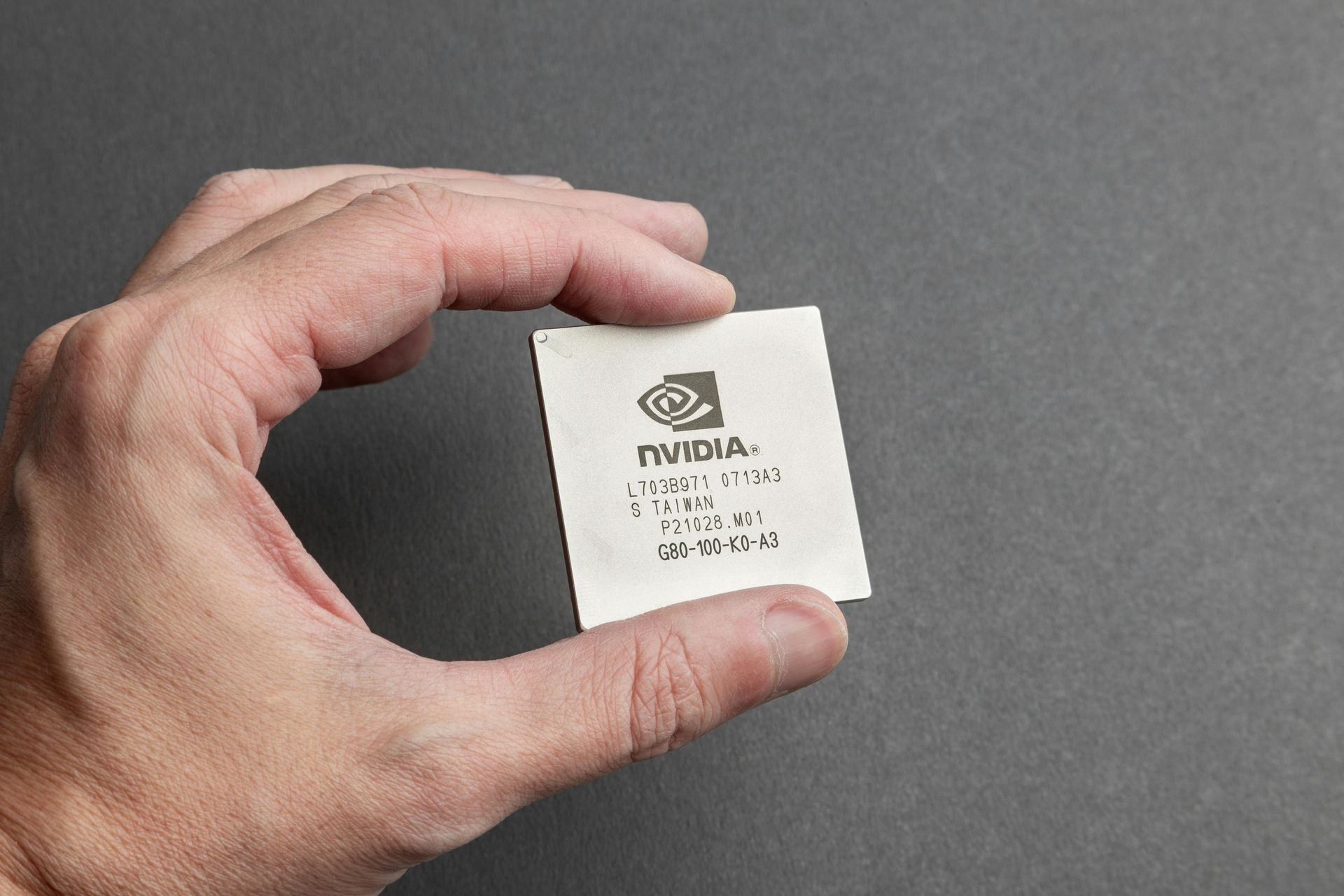 Een hand die een chip van Nvidia vasthoudt.