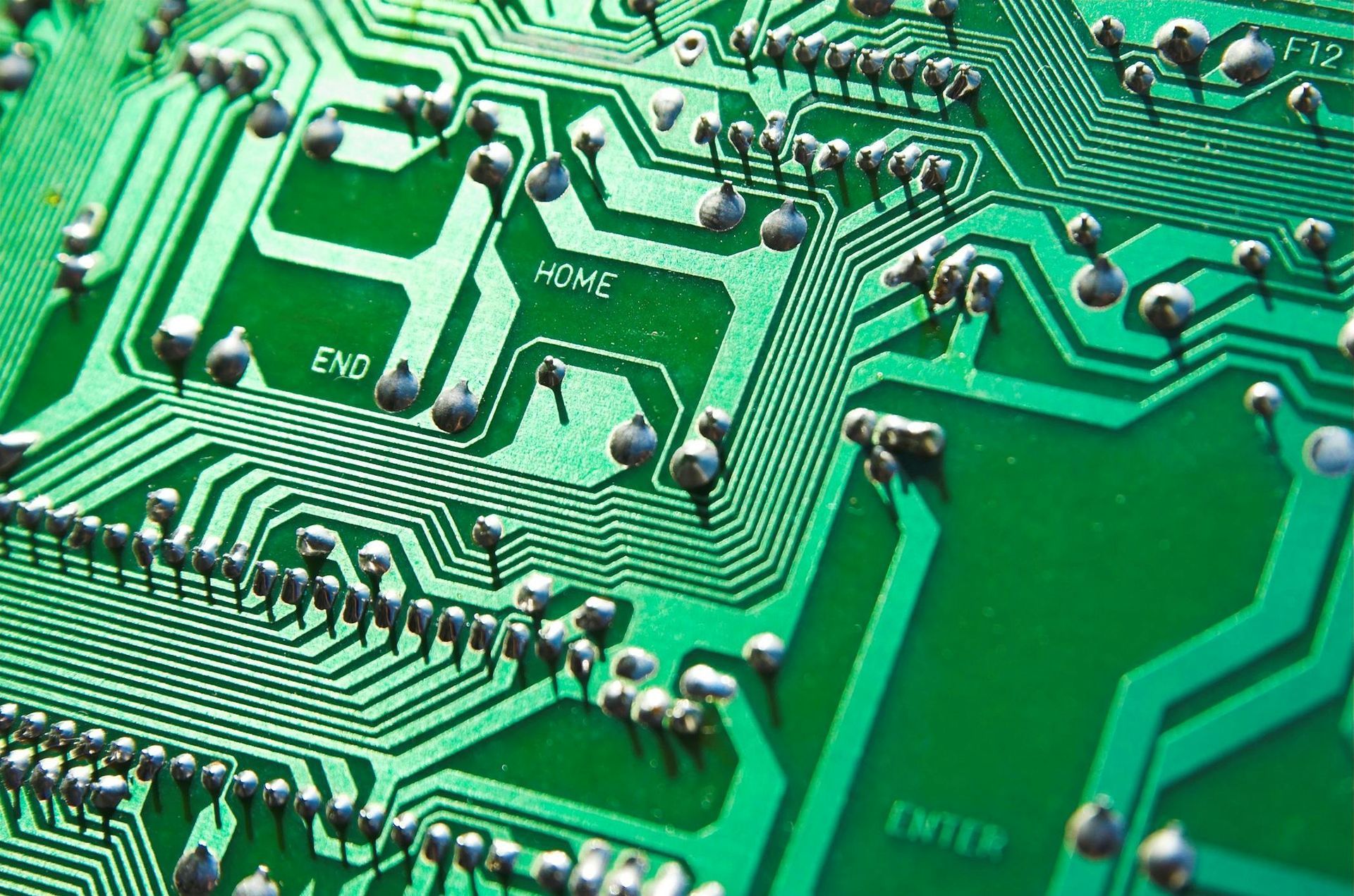 Een closeup van een groene printplaat met daarop allerlei IC's etc.
