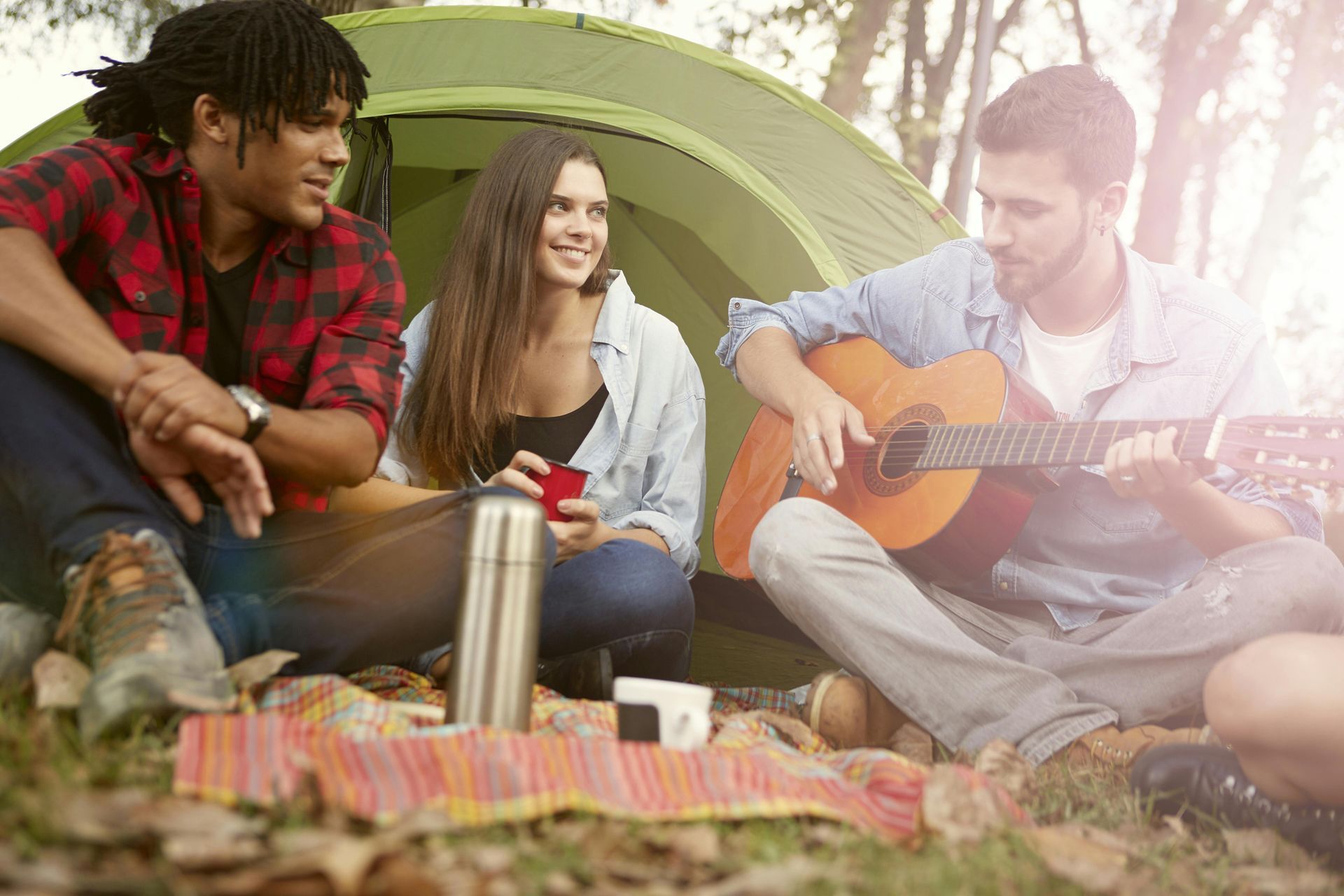 Friends enjoying a weekend camping trip with Camp in a Box rental gear and a cozy tent setup
