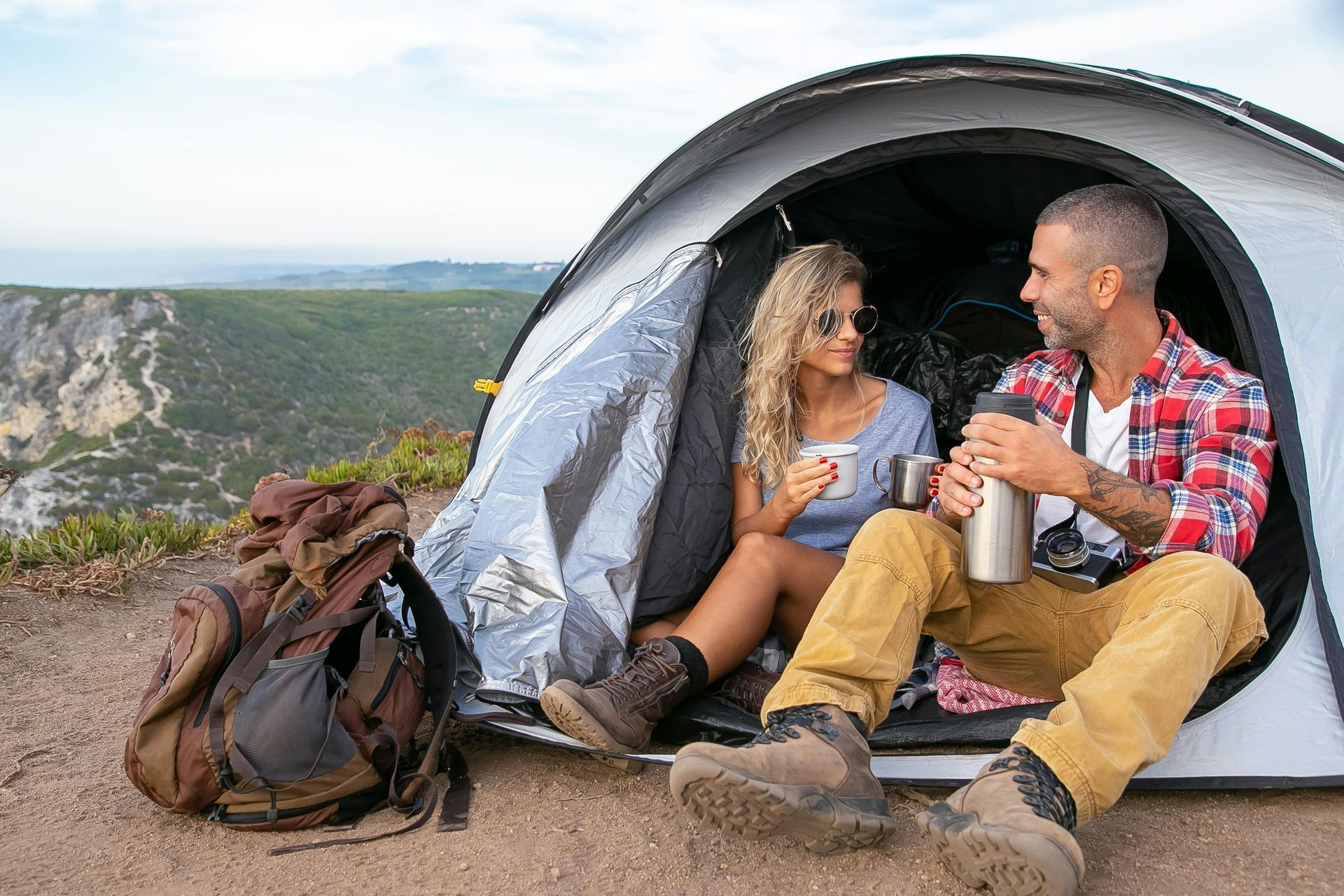 Couple enjoying a scenic campsite with rental gear from Camp in a Box near a tent