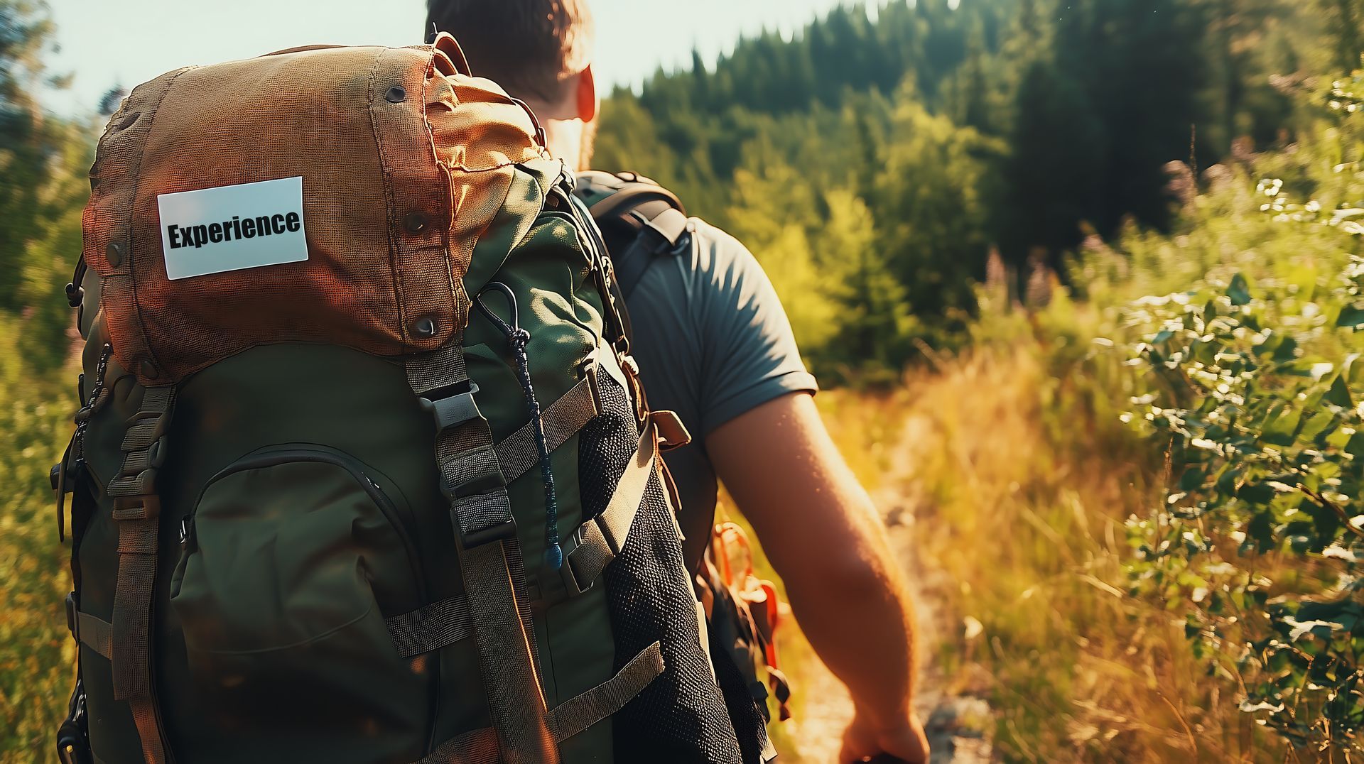 Backpacker on forest trail with full camping gear, highlighting experience over owning equipment