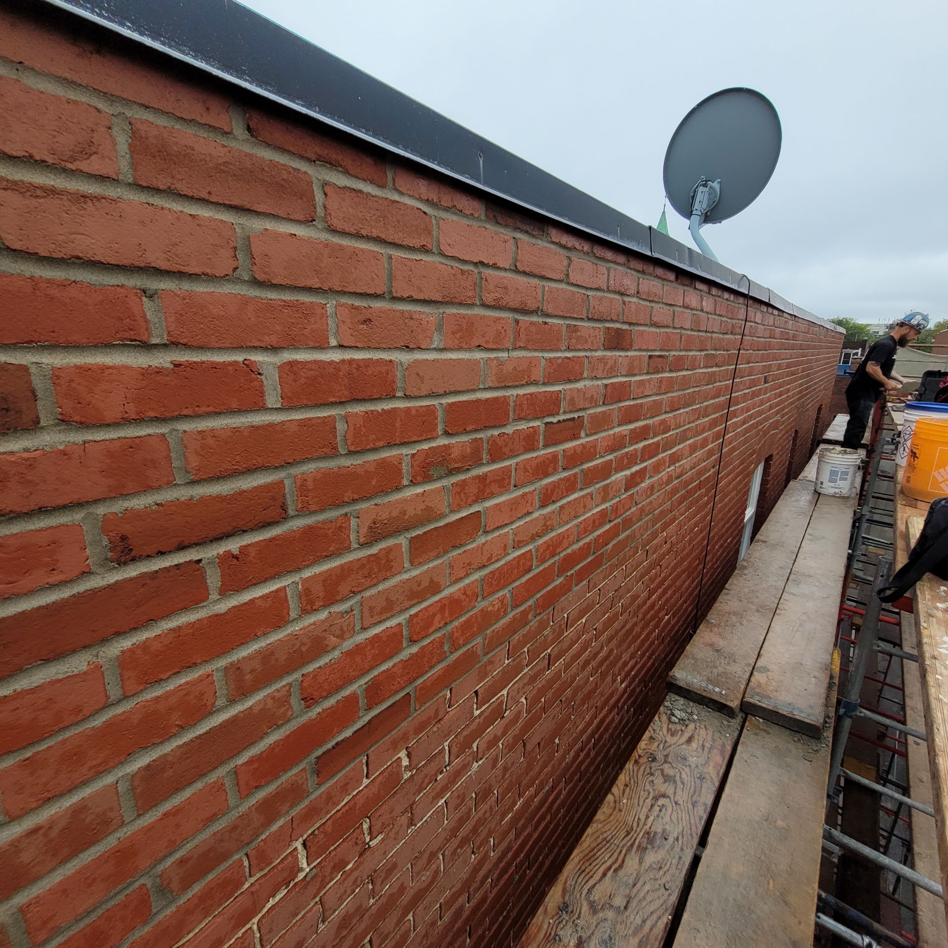 Un mur de briques avec une antenne parabolique dessus