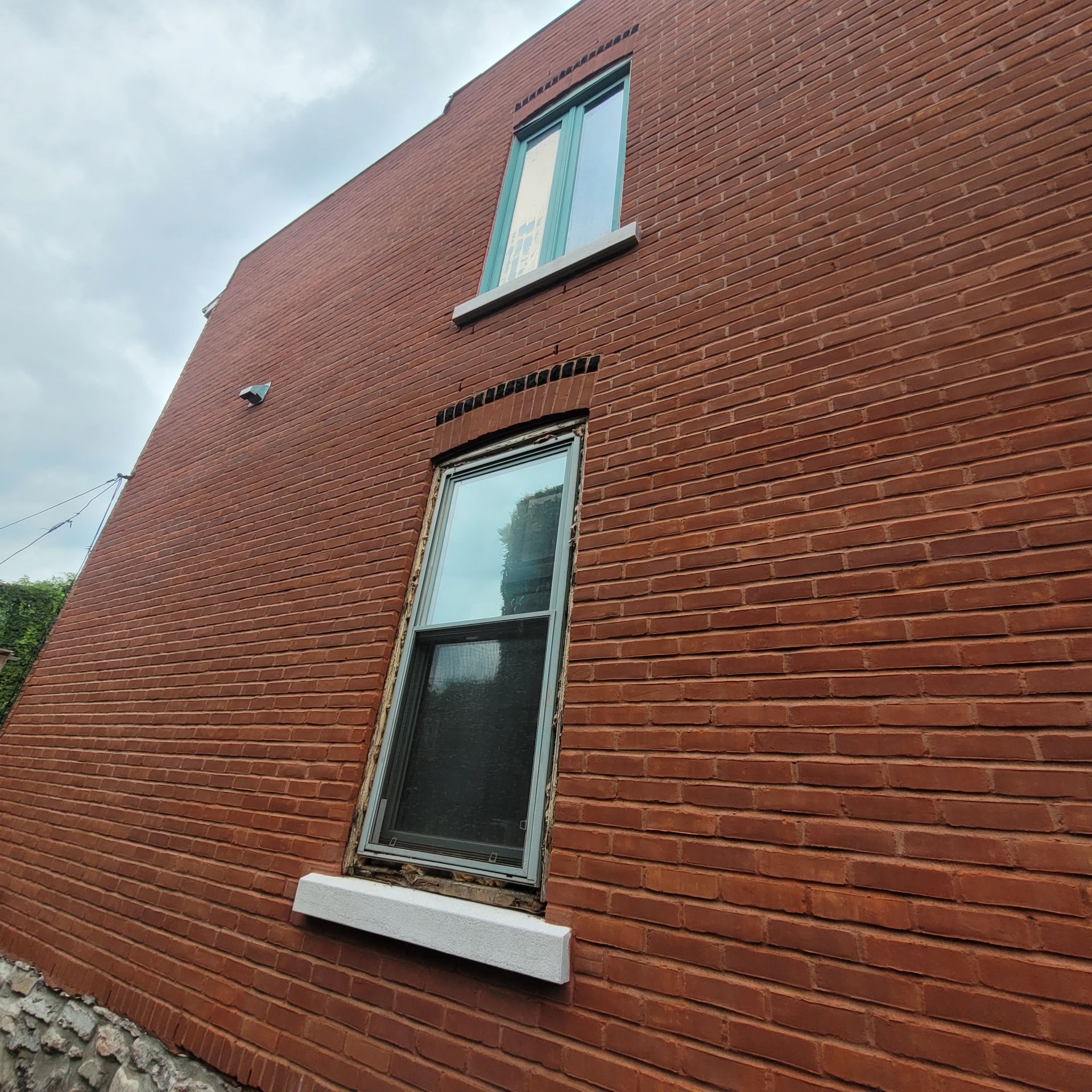 Un bâtiment en briques rouges avec une fenêtre sur le côté.