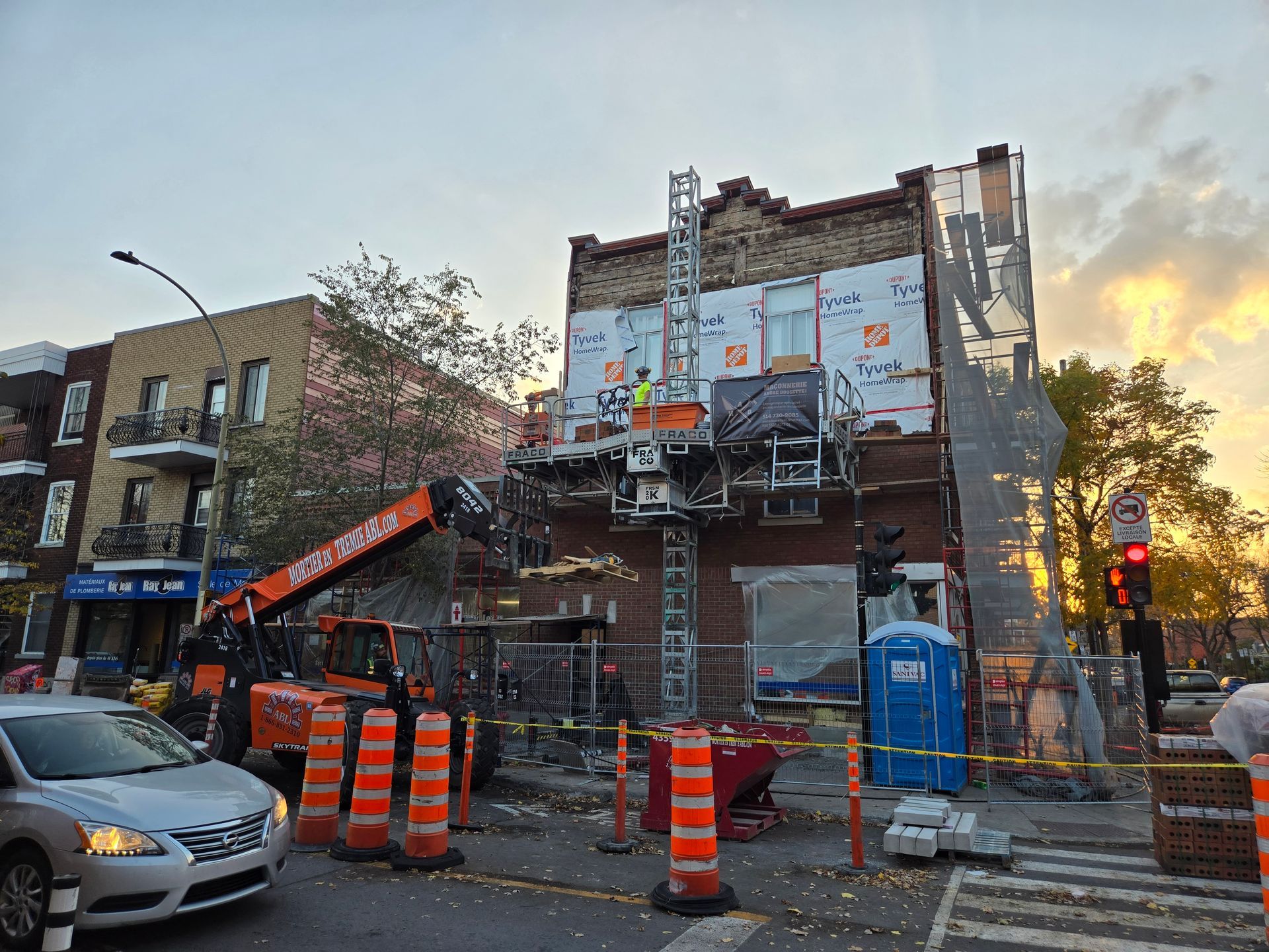Une voiture roule dans une rue devant un bâtiment en construction.