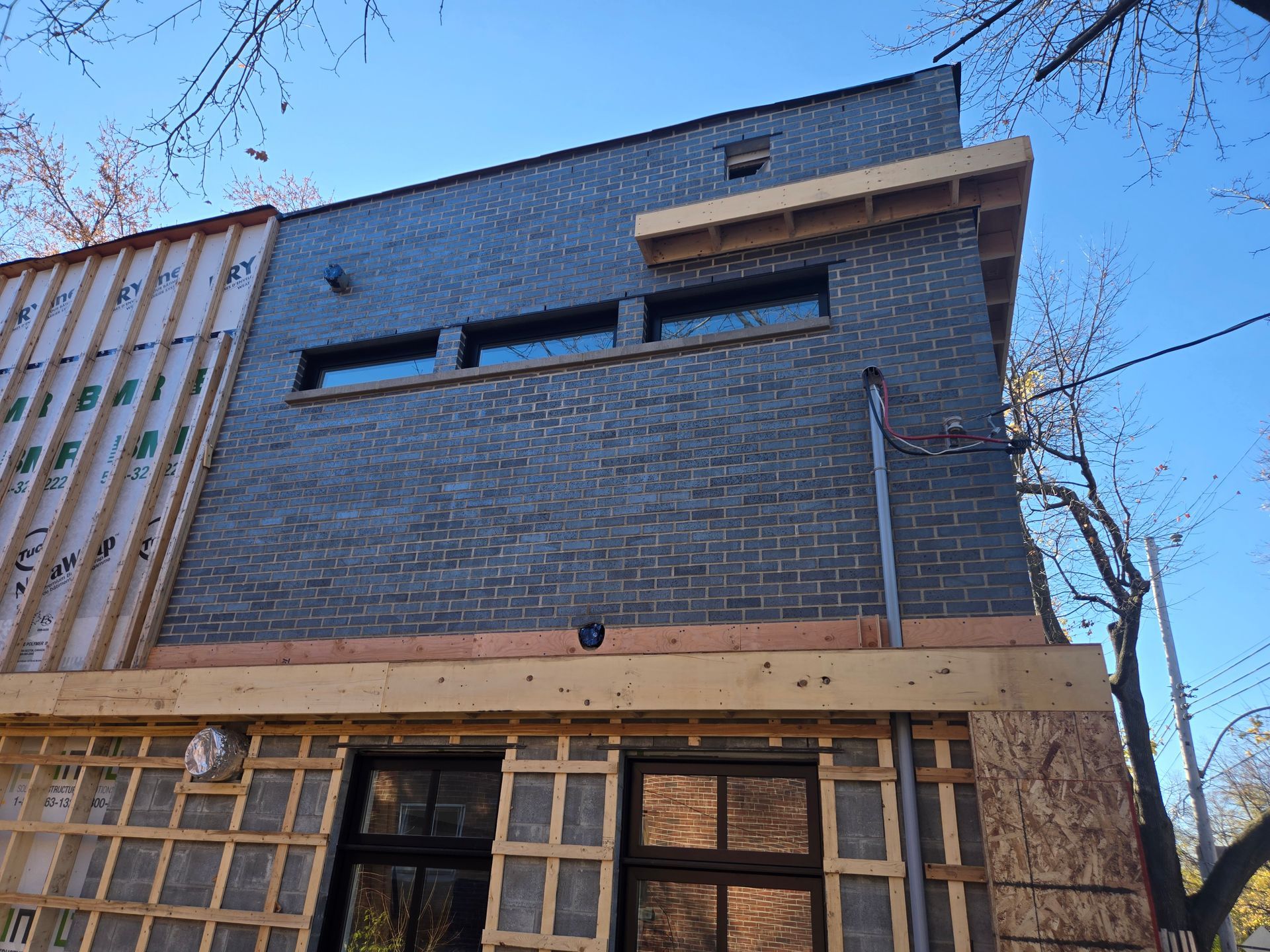 Un bâtiment en briques est en construction avec un ciel bleu en arrière-plan