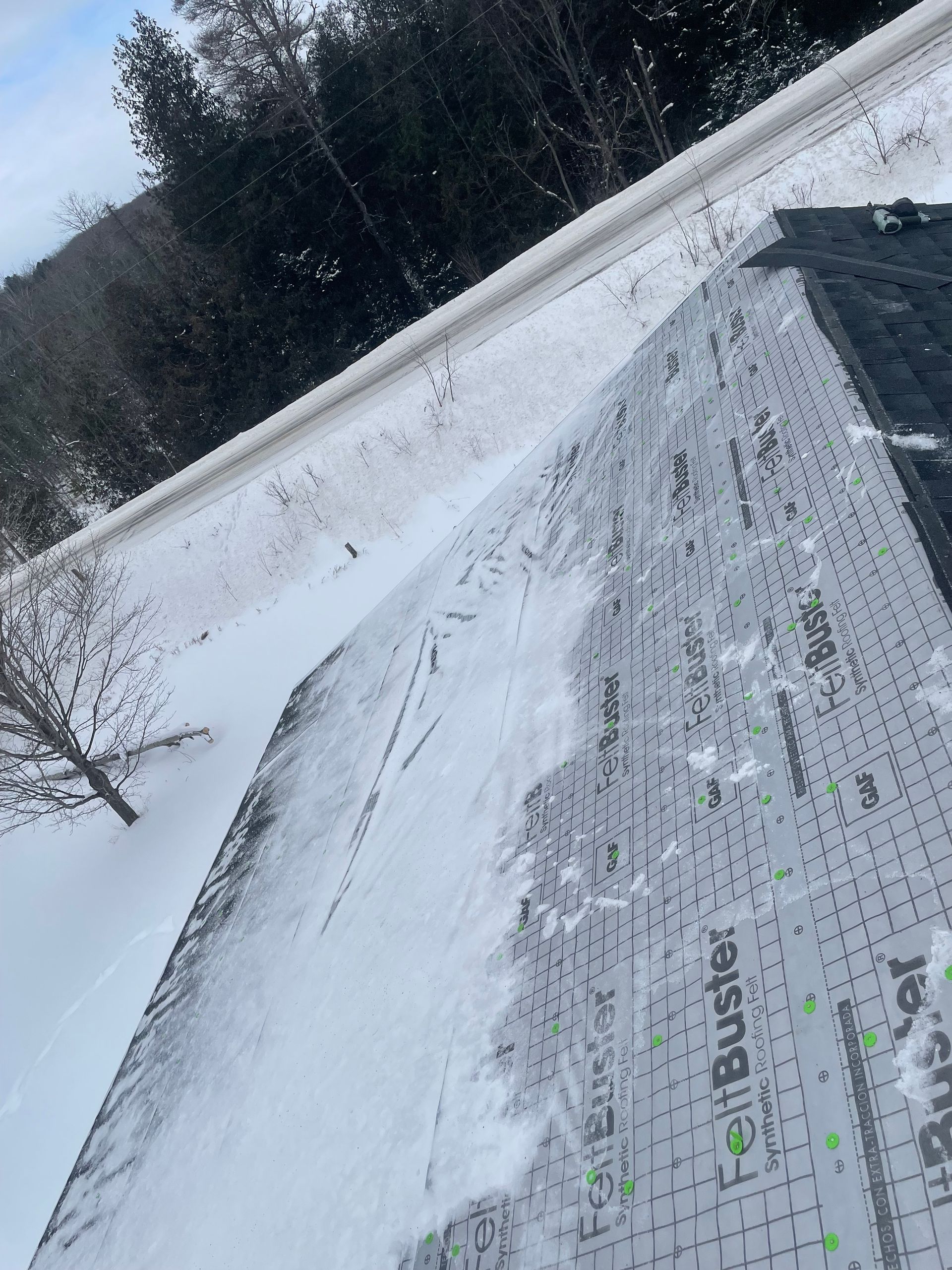 Top view of an asphalt roof after ice dam removal by Alpine Brothers Construction