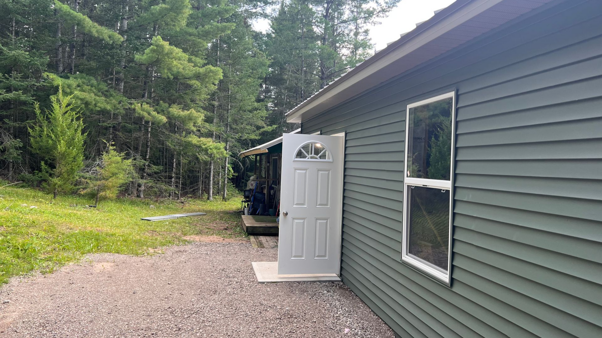 Side view of  a house with vinyl siding and new window and door installation.