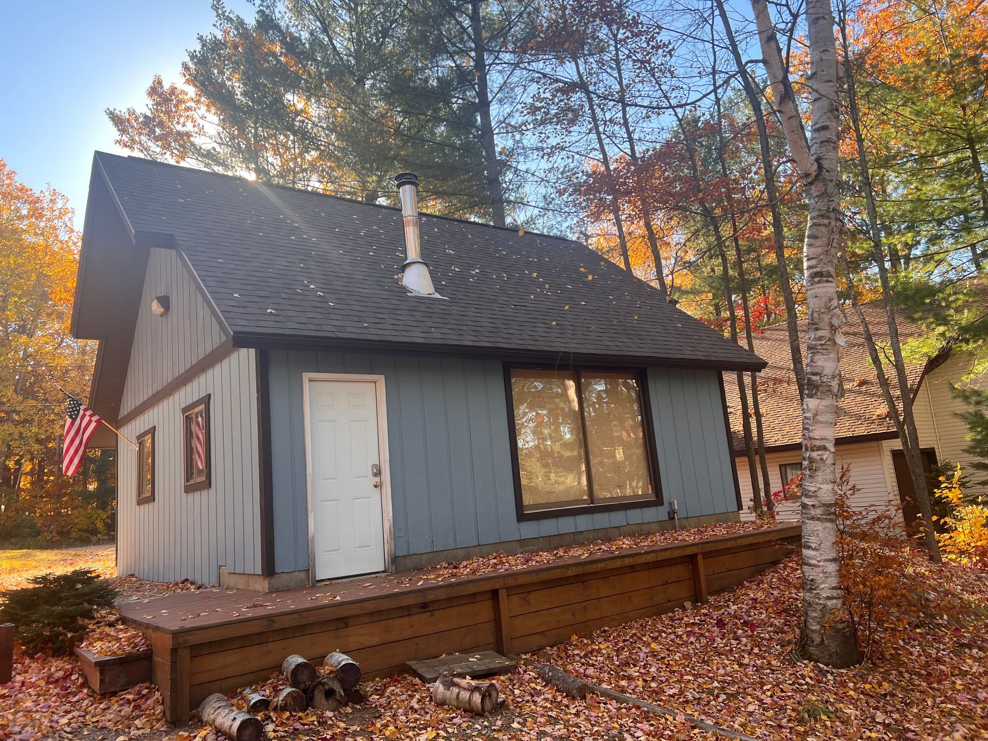 A shed in Gaylord, MI with new blue vinyl siding and a dark grey asphalt roof