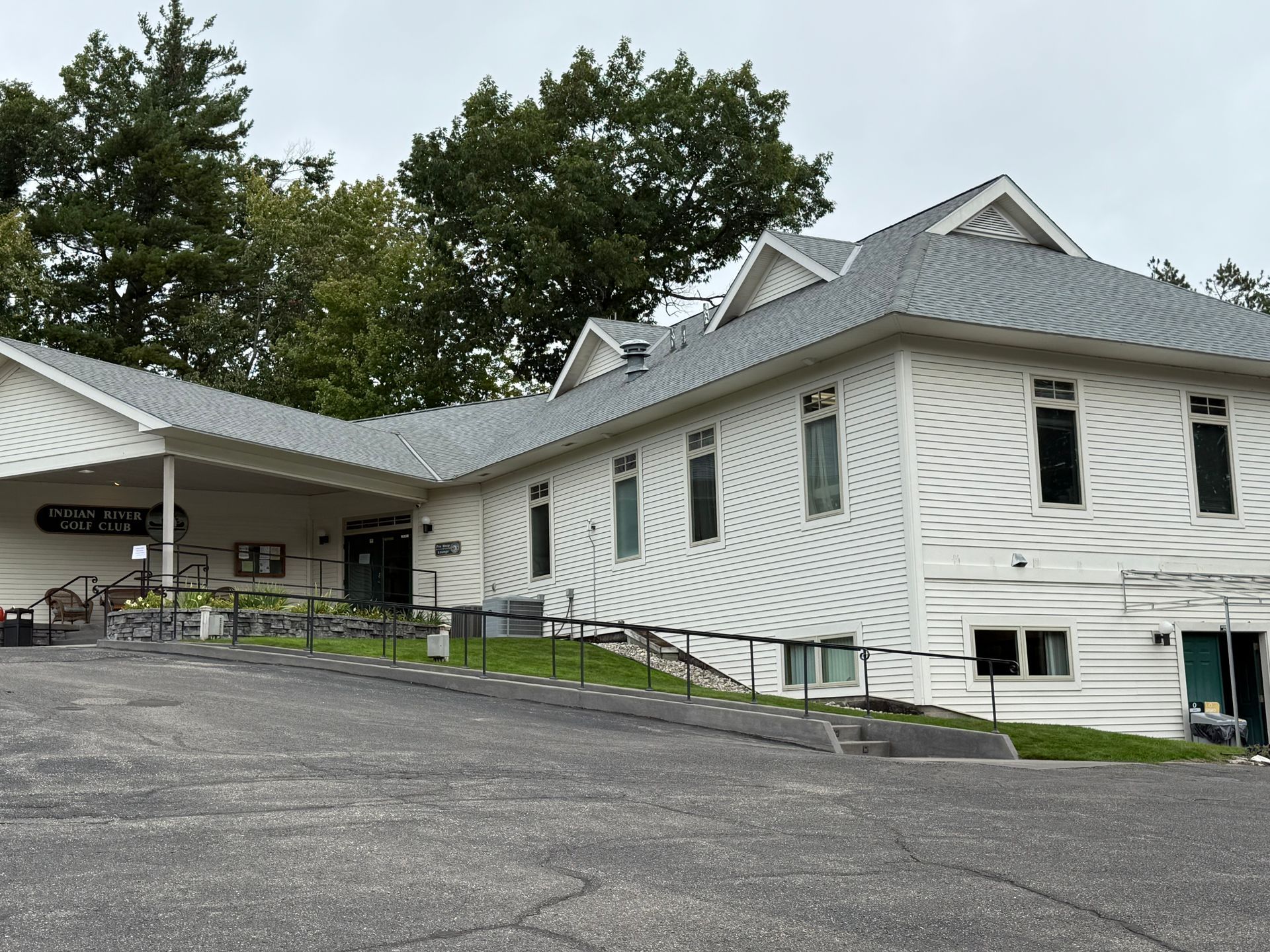 Image of a golf course clubhouse in Gaylord, MI with white siding installation and grey asphalt shingle roof installation