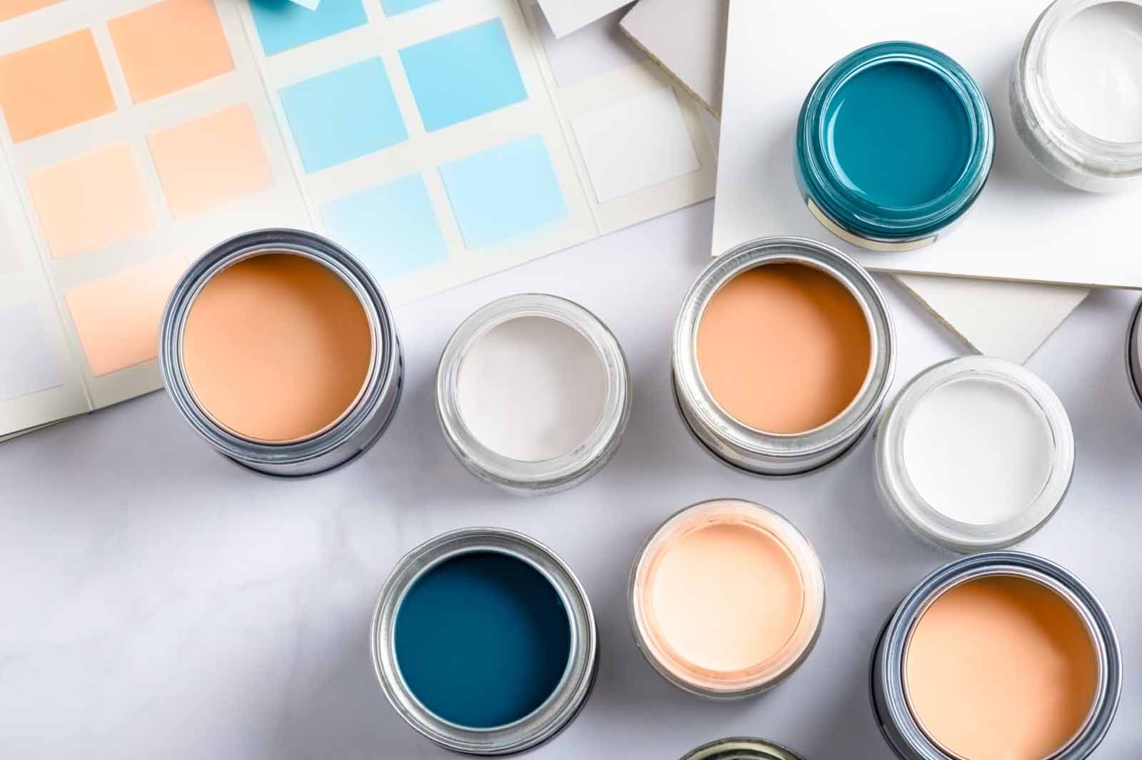 A bunch of cans of paint are sitting on a table.