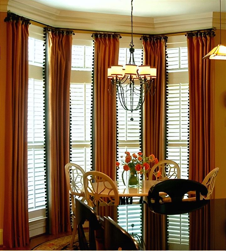 A ceiling fan hangs from the ceiling above a window with blinds