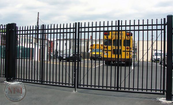 A black sliding gate is open in front of a house.