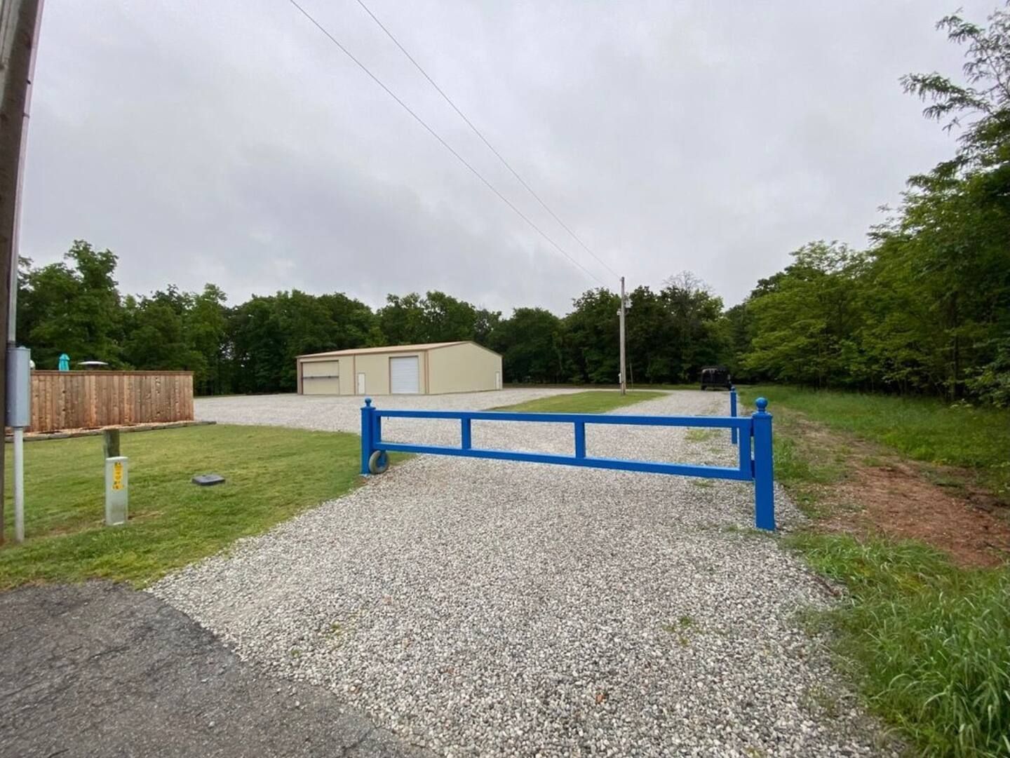 A gravel road with a blue gate in the middle of it