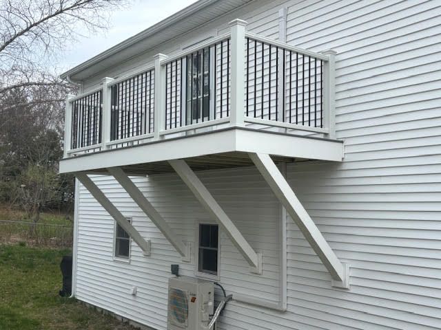 A white house with a balcony on the side of it