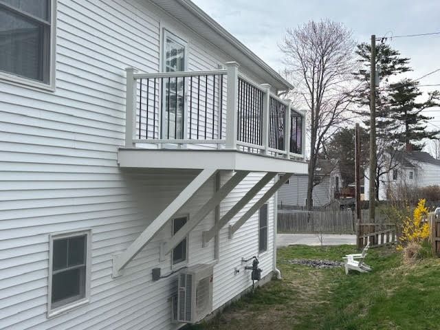 A white house with a balcony on the side of it