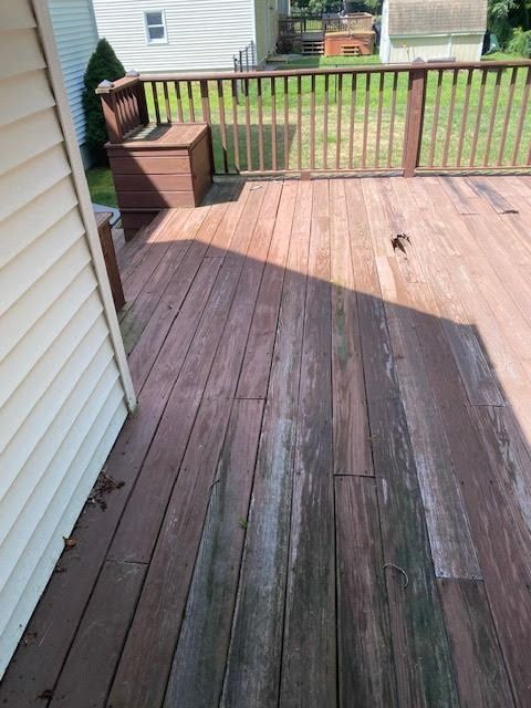 A wooden deck with a white house in the background.