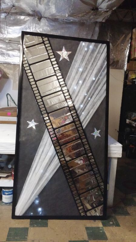 A picture of a film strip with stars on it is hanging on a wall