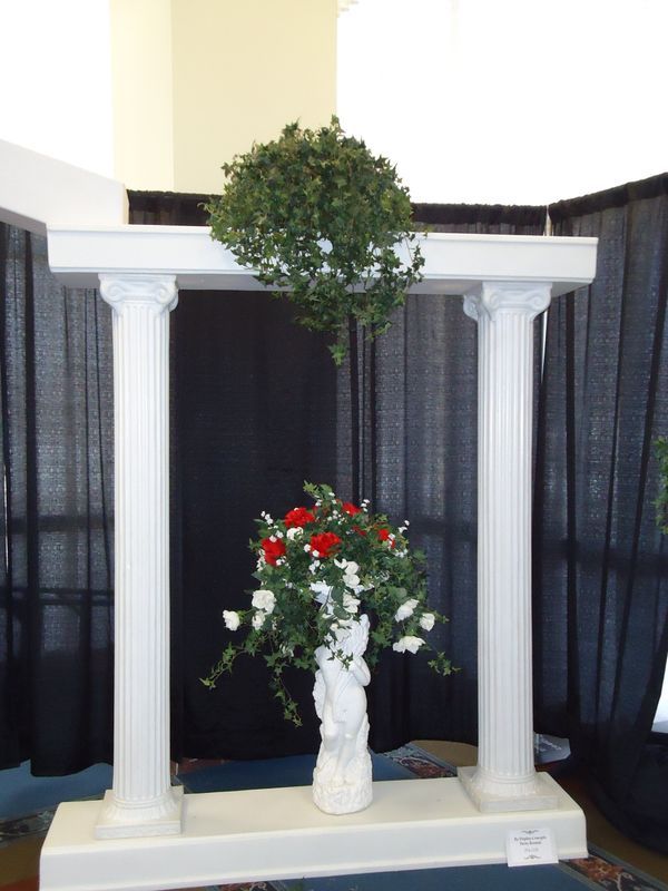 A white pillar with a vase of flowers on it
