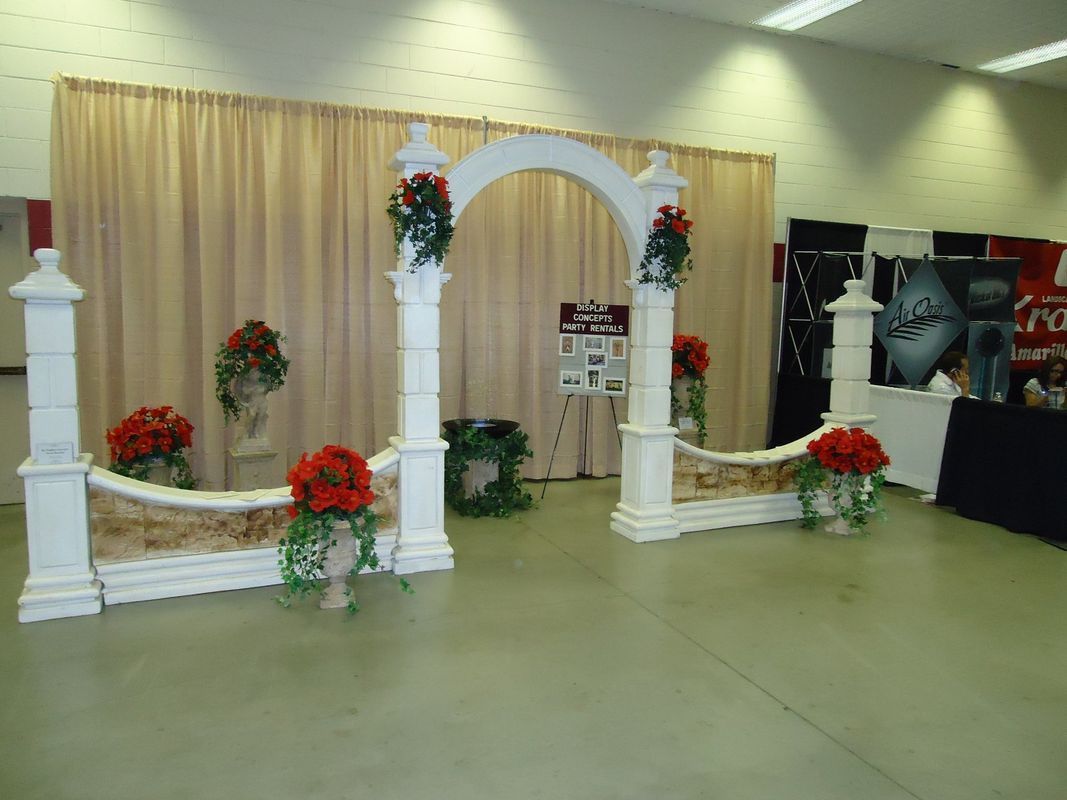 A room with a white arch and red flowers on it