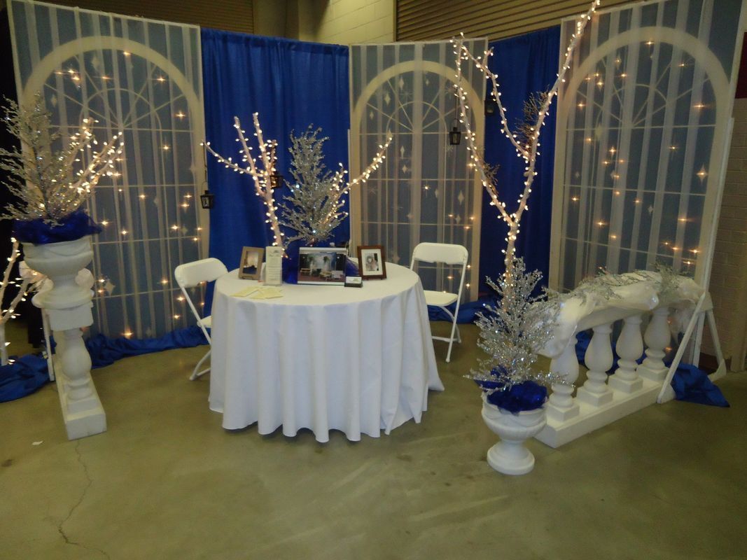A table with a white table cloth is in front of a blue backdrop
