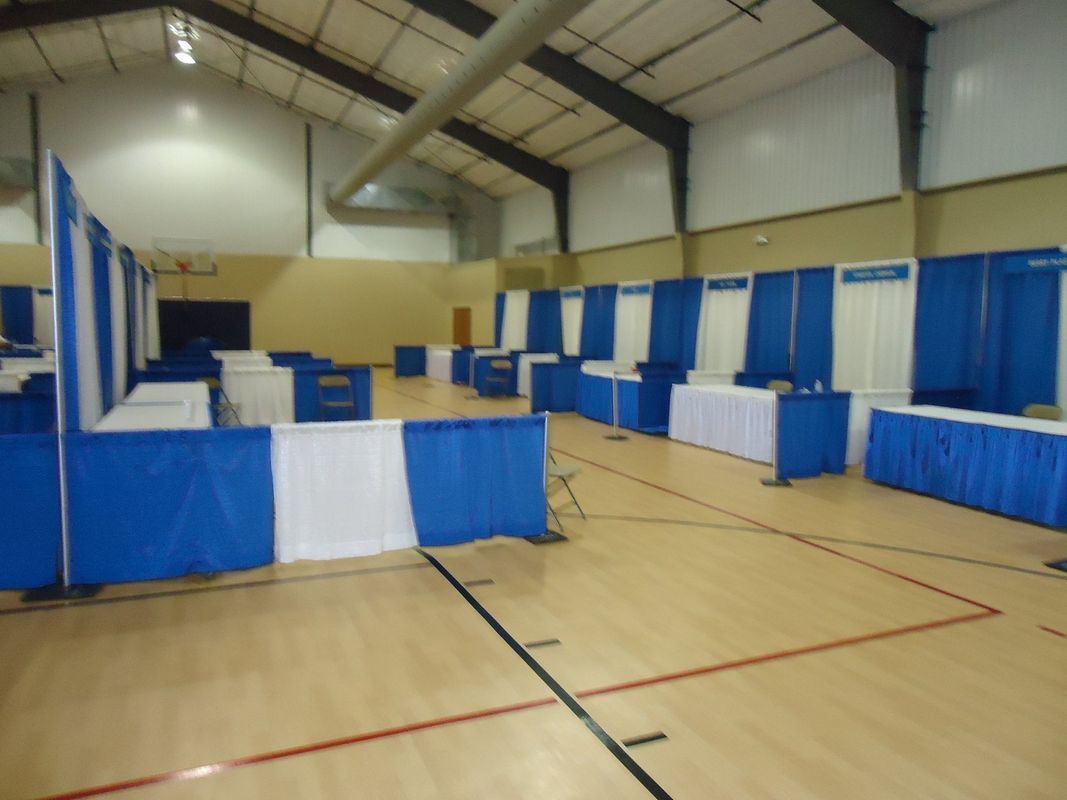 A gym with blue and white curtains and tables