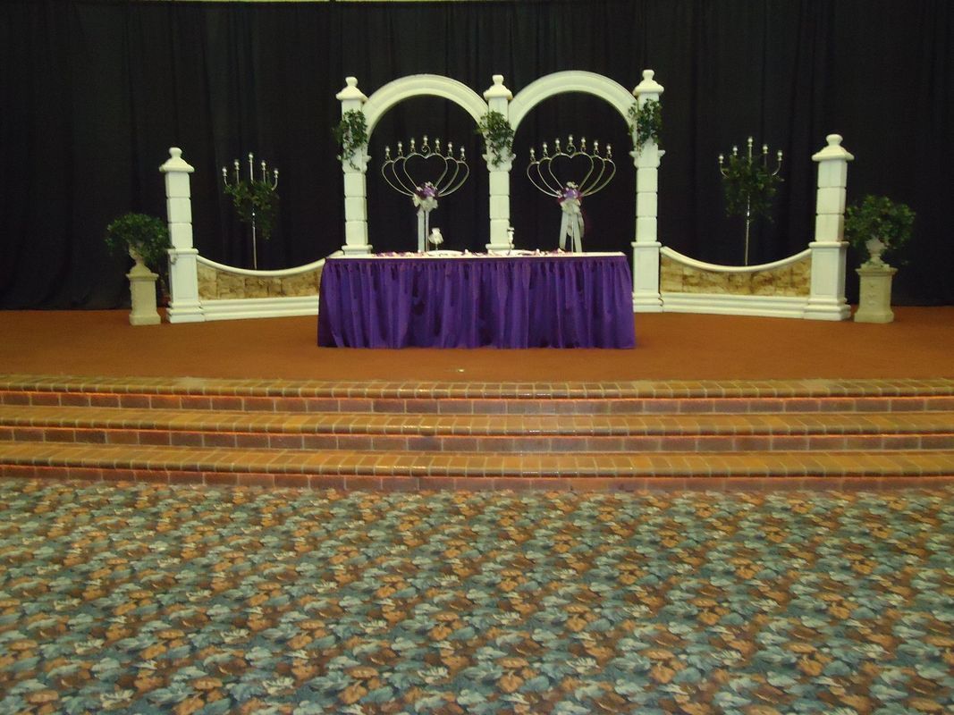 A stage with a purple table and candles on it