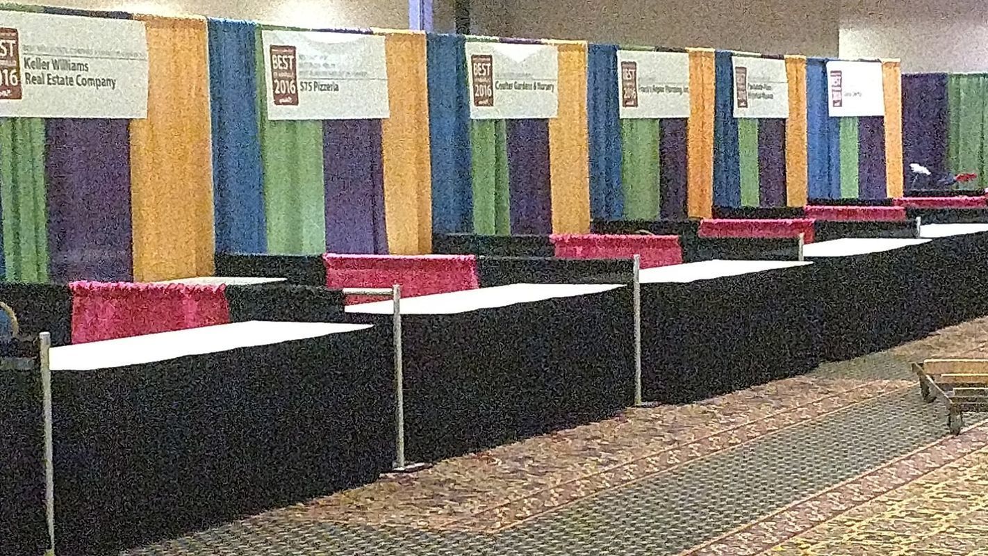 A row of tables in a room with colorful curtains