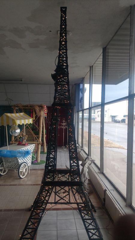 A large model of the eiffel tower is sitting in a room next to a window